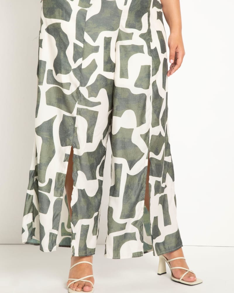 Side of a model wearing a size 16 Pull On Wide Leg Pant with Slit Hem in Sand Blocks - Green by ELOQUII. | dia_product_style_image_id:295432